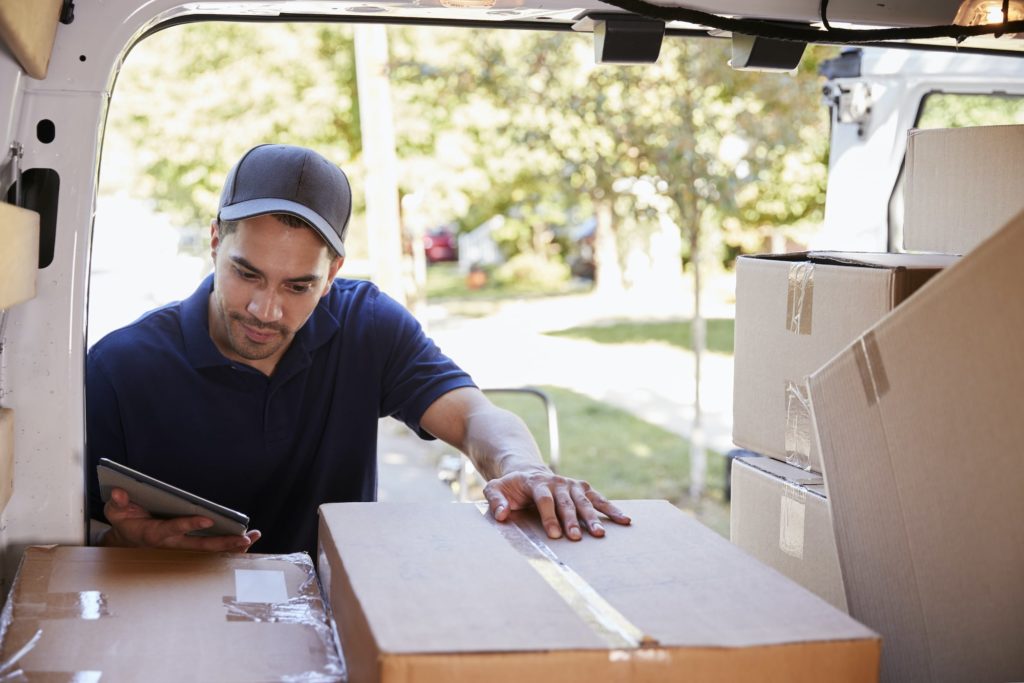 Man Organizing boxes in back of a delivery truck